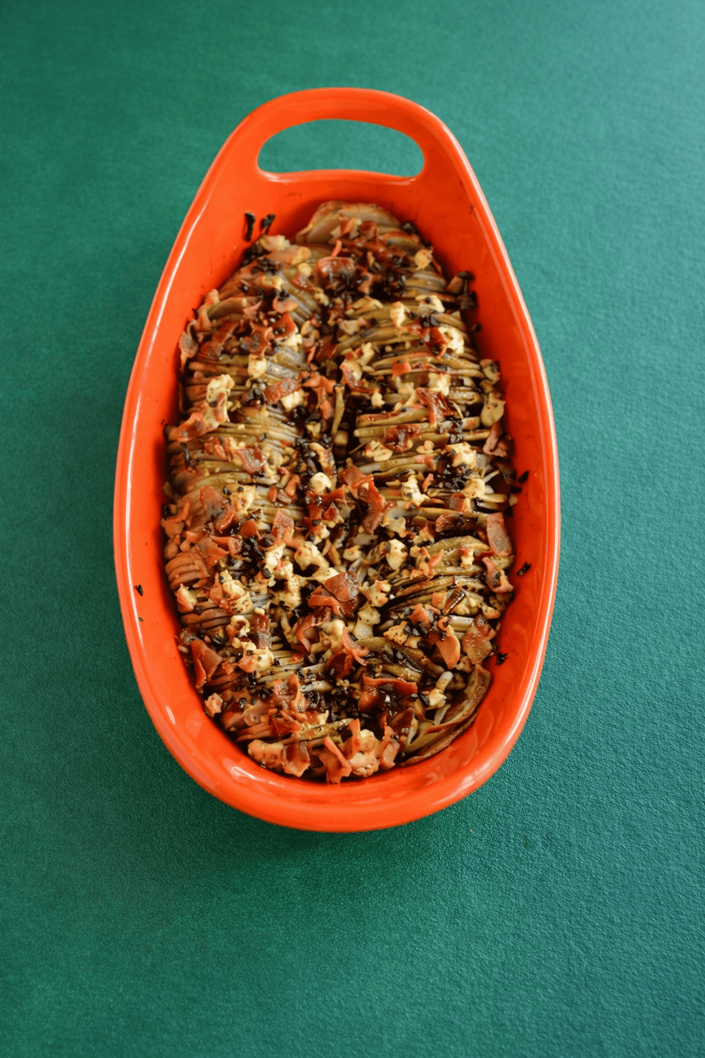 A baking dish of golden brown potatoes with bacon on top.