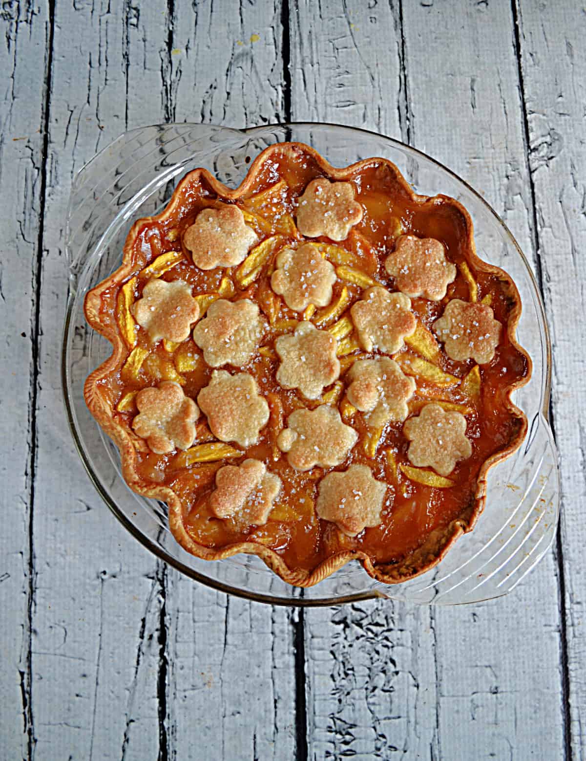 A Peach Pie with flower pie crust cut outs on top. 