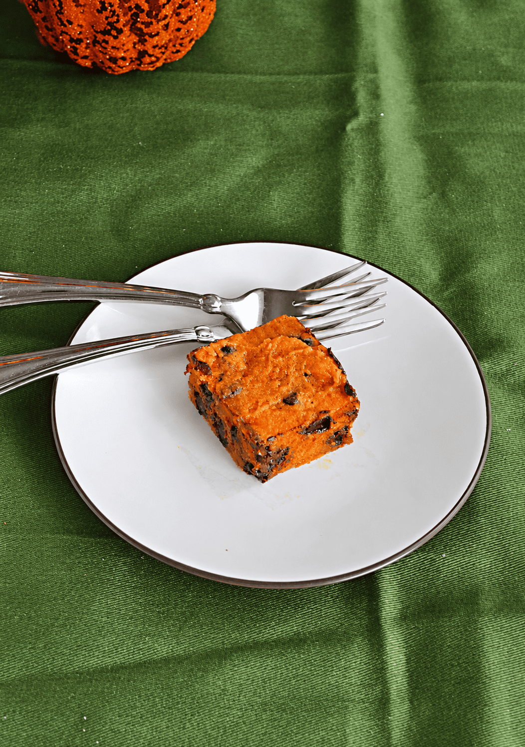 A plate with a pumpkin bar and two forks on it.