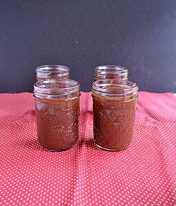 Four glass jars of apple butter.
