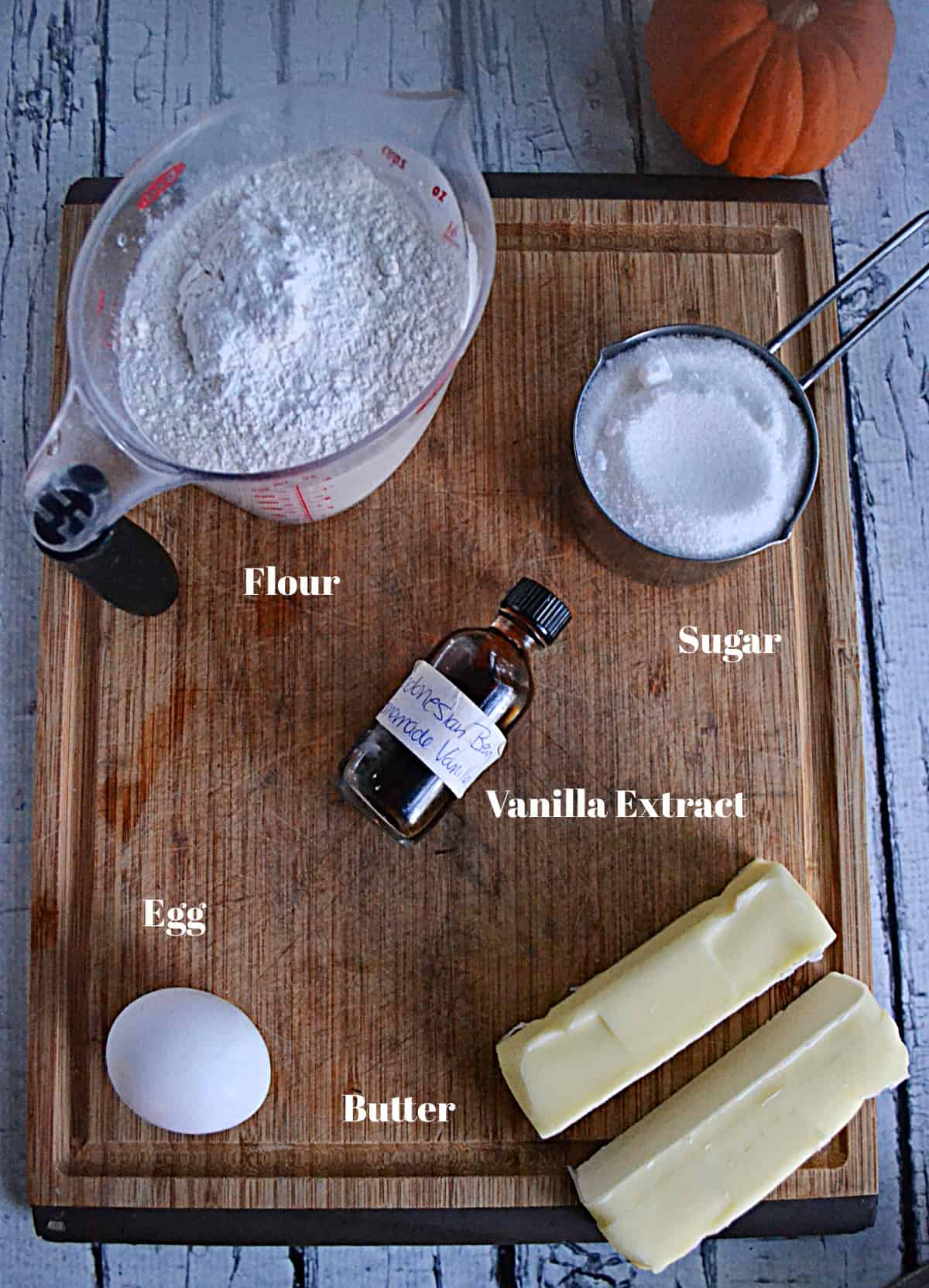 A board with all the ingredients for making sugar cookies. 