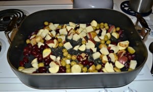 Potatoes, grapes, and olives ready for roasting with a whole chicken