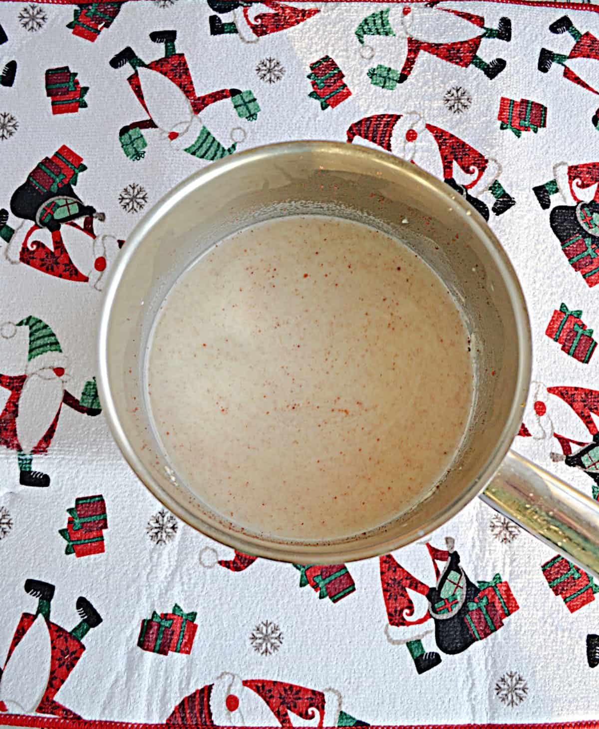 A saucepan with white hot cocoa in it.