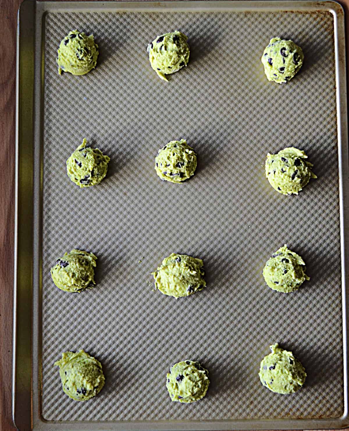 A baking sheet with cookie dough balls on it. 