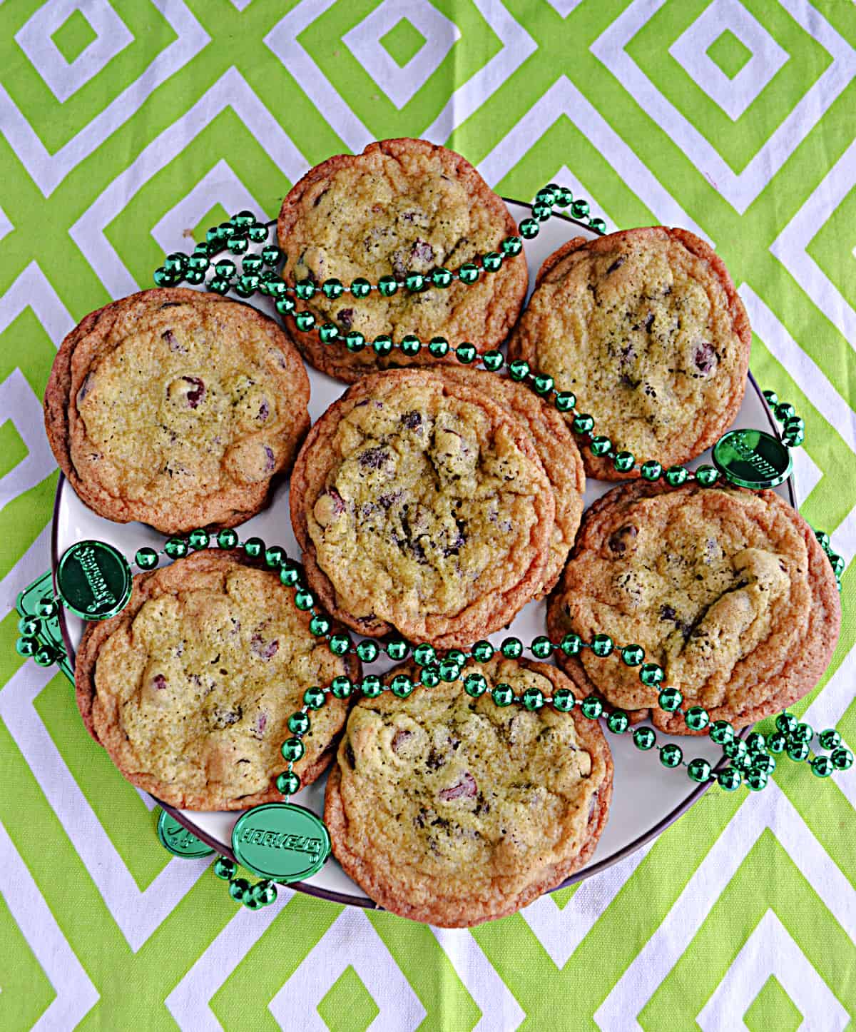 A plate of cookies with green beads around it. 