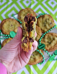 A hand holding a cookie split in half.