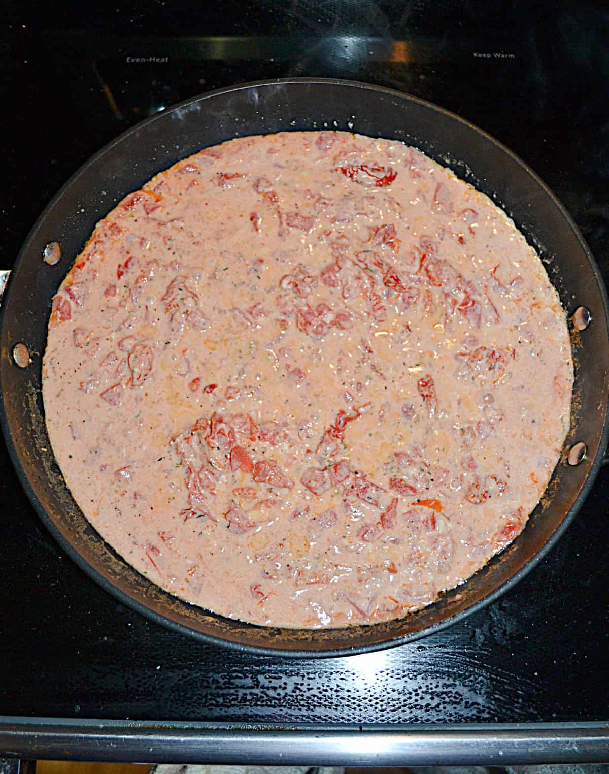 A pan of sauce and tomatoes.