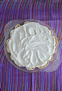 A pie topped with homemade whipped cream.