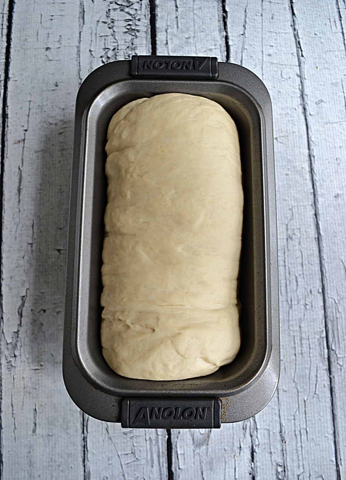 A loaf of bread dough in a loaf pan.