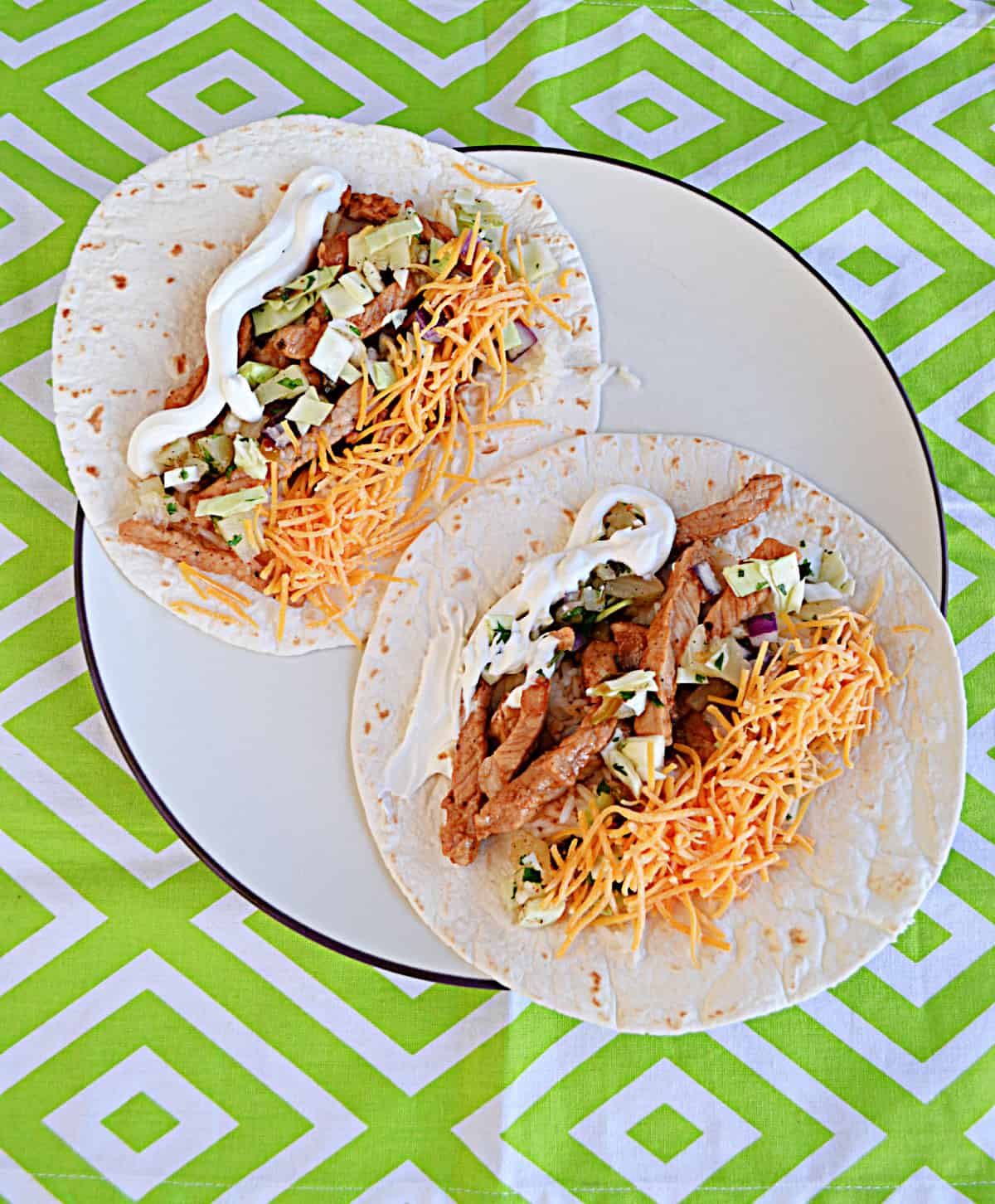 Two pork soft tacos on a plate.