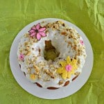 Grab a slice of this tropical Hummingbird Cake with bananas, pineapple, pecans, and a cream cheese glaze with chocolate flowers on top!