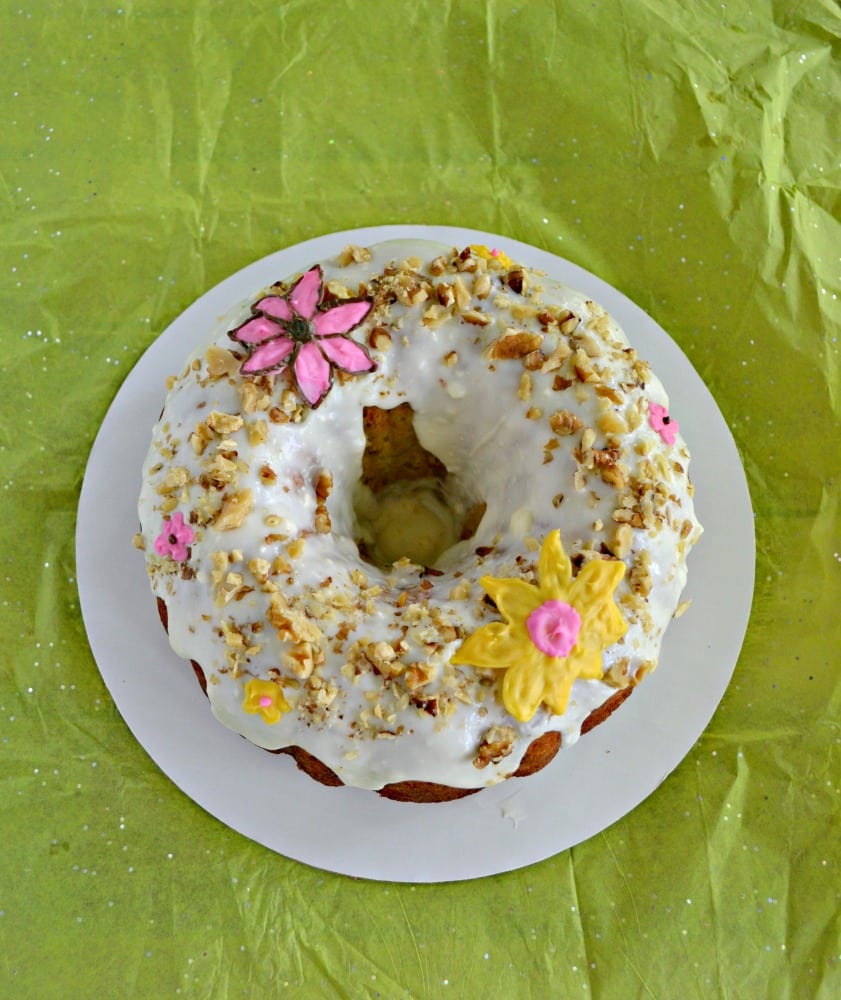 Grab a slice of this tropical Hummingbird Cake with bananas, pineapple, pecans, and a cream cheese glaze with chocolate flowers on top!