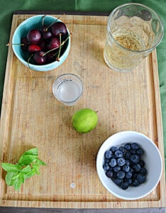 A cutting board with ingredients for making a mojito.