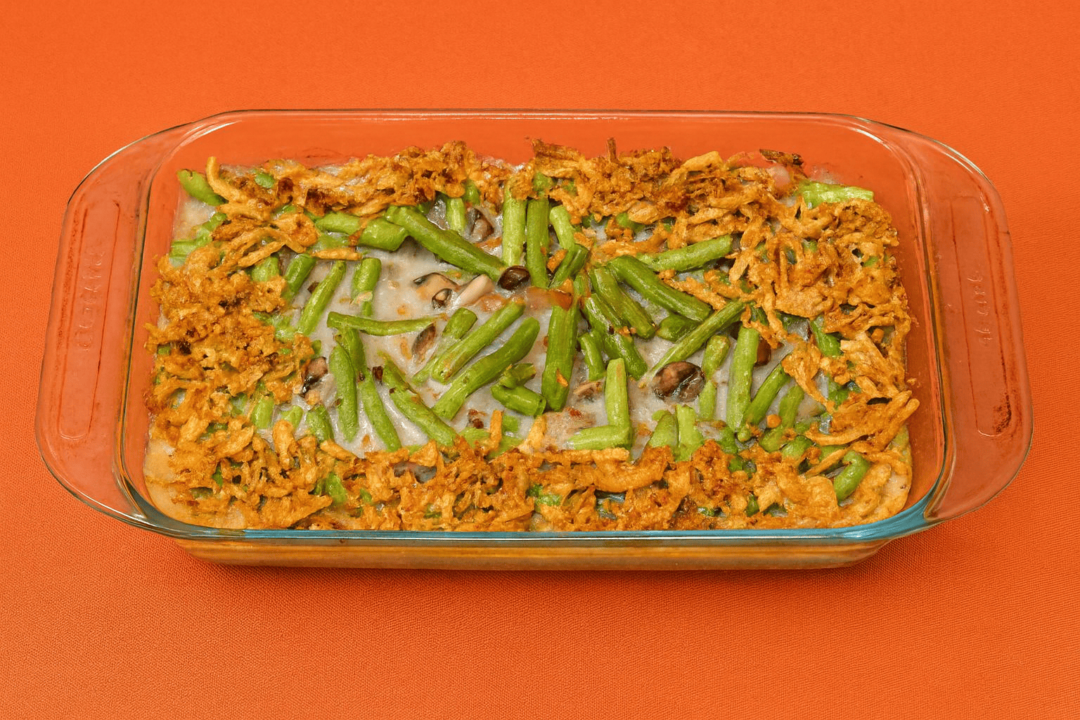 A baking dish with green beans and fried onions on top.