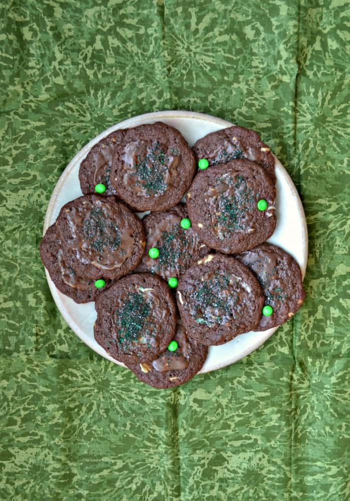A plate of chocolate cookies with sprinkles on top. 