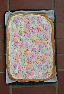 A layer of white chocolate, conversation hearts, and sprinkles makes this Sugar Cookie Bark perfect for Valentine's Day!