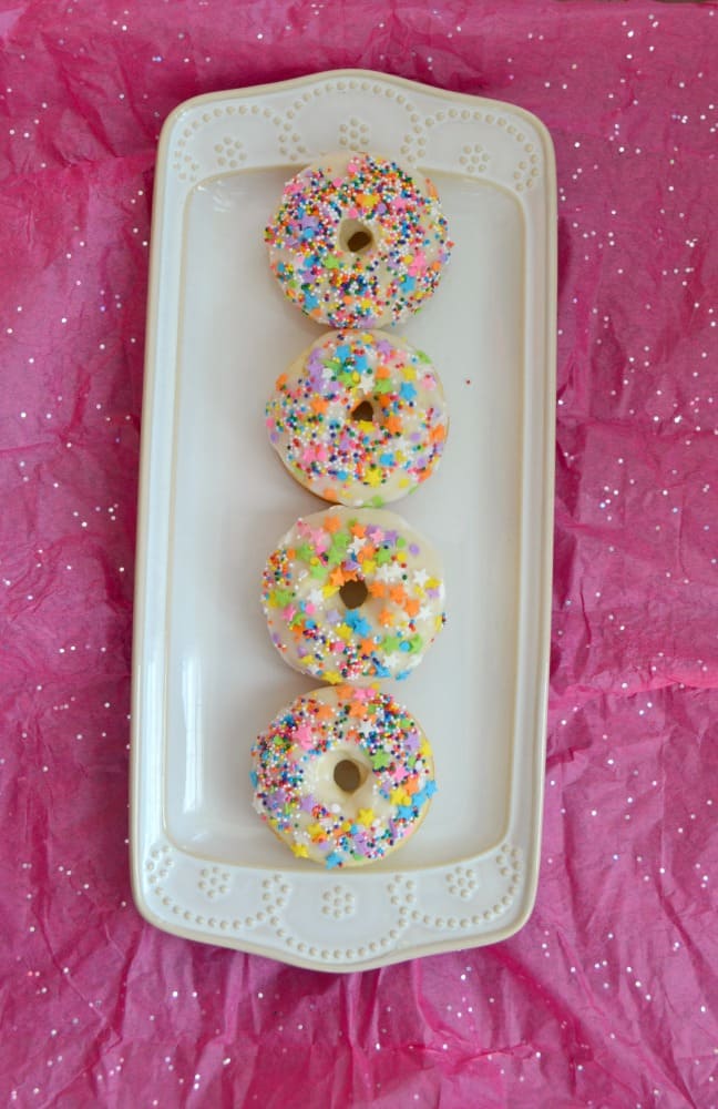 Have trouble getting your kids to eat breakfast? They'll run to the table for these Baked Vanilla Donuts with Vanilla Glaze and fun Sprinkles!