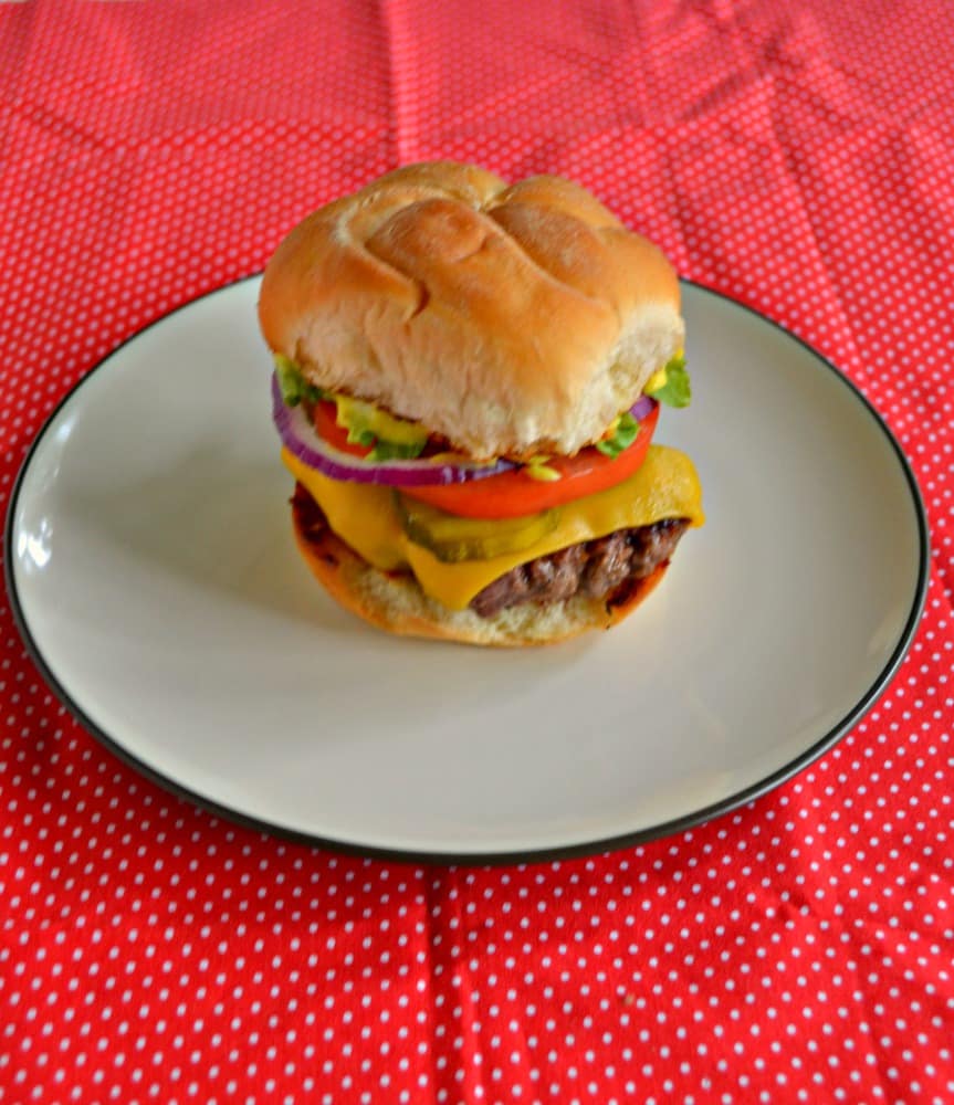A photo of a hamburger piled high with cheese, tomatoes, onions, lettuce, and burger sauce. 