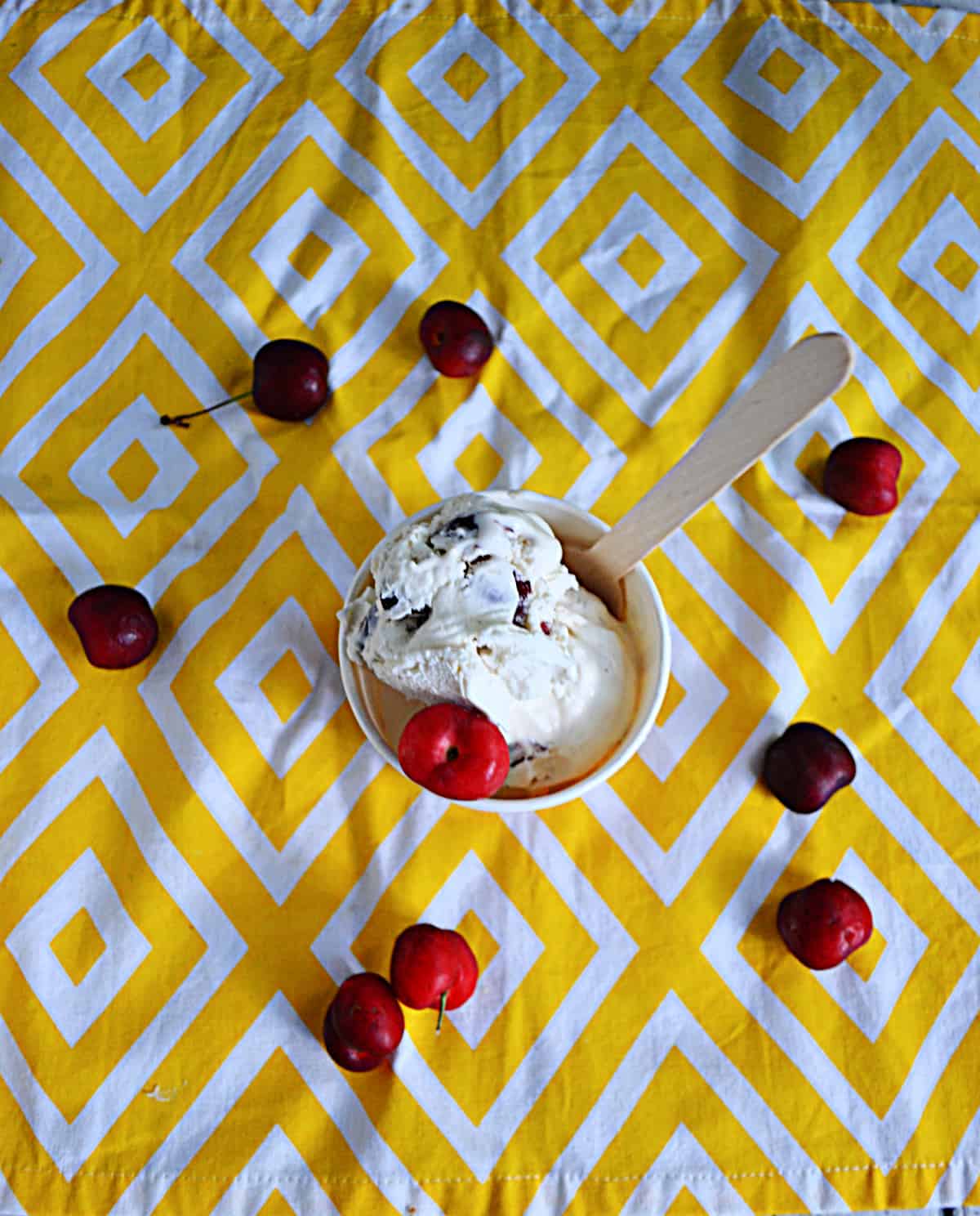 A top view of a cup of cherry vanilla ice cream with cherries all around.