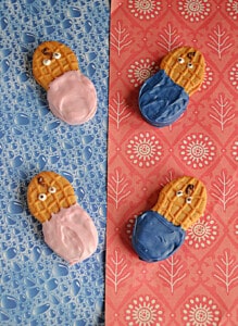 Four Nutter Butter Cookies decorated in pink and blue to look like babies.