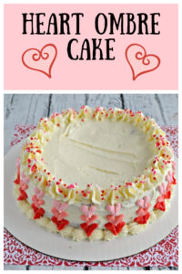 Pin Image: Text, a Valentine's Daay cake decorated with red, pink, and baby pink ombre hearts on the side and sprinkles around the top.