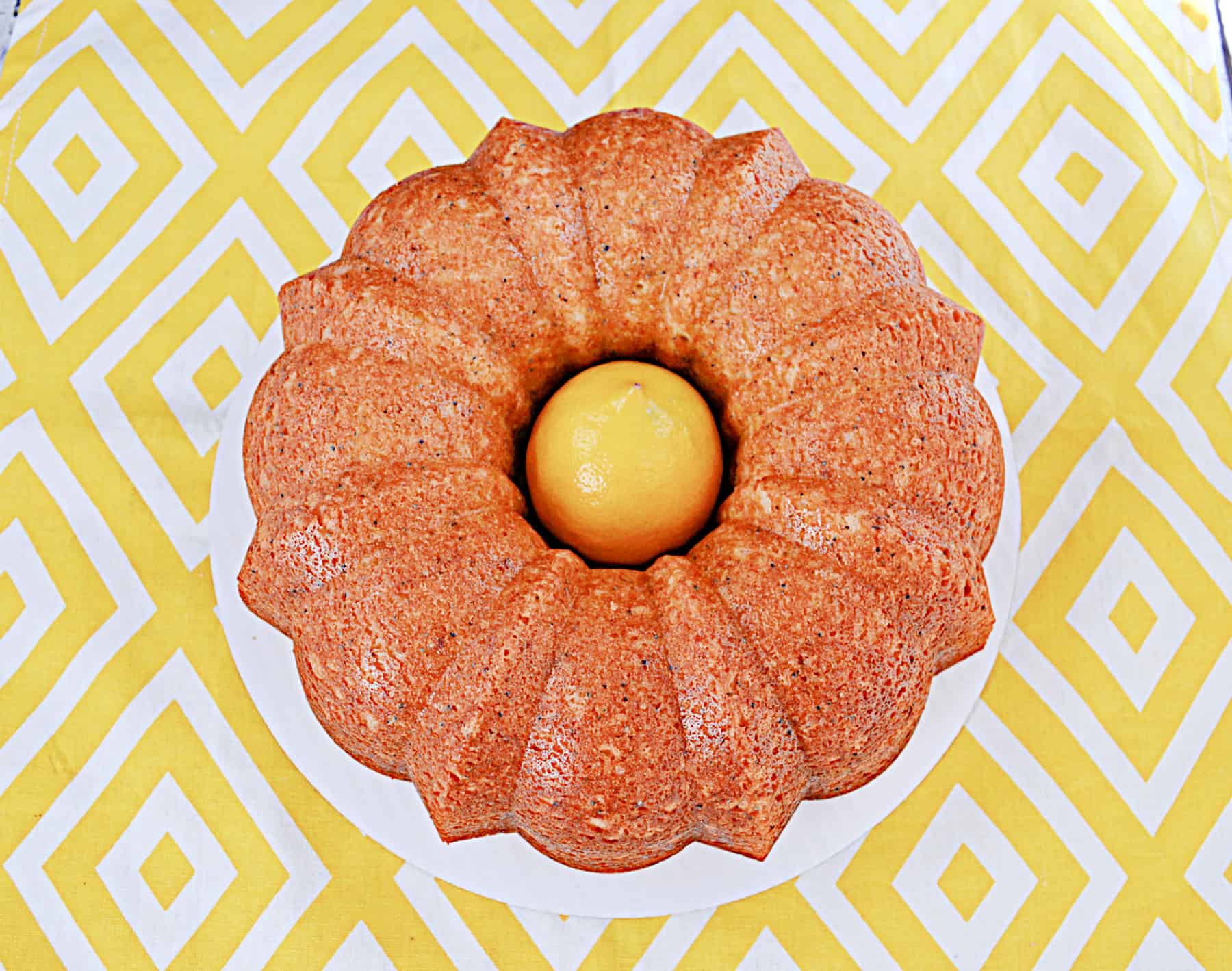 A golden brown Bundt Cake with a lemon in the middle.