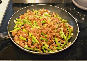 Saute sausage, asparagus, and onions for a delicious breakfast quiche