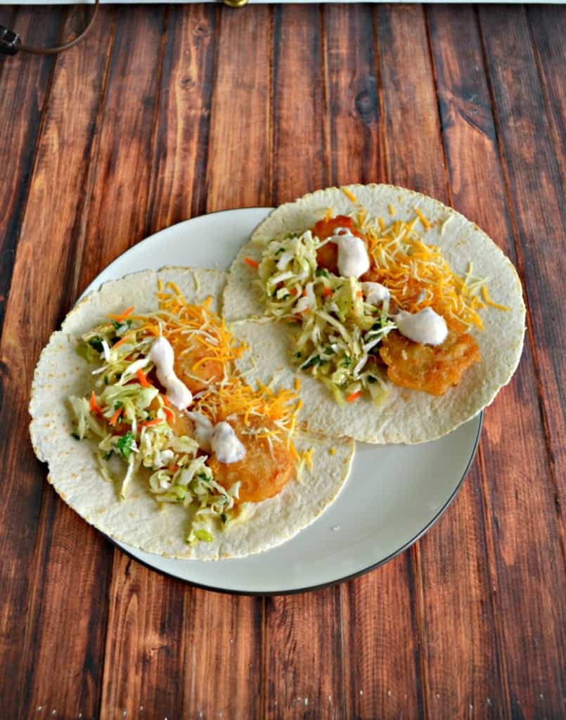 We love these delicious beer battered fish tacos topped with fresh lime slaw, cheese, and salsa sour cream!