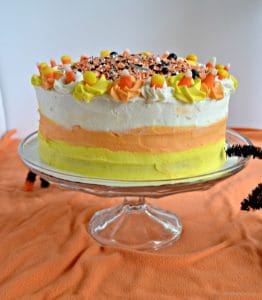 A side view of a yellow, orange, and white candy corn cake.