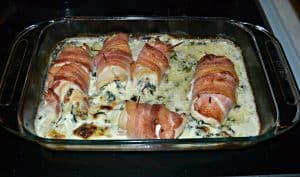 Chicken wrapped in bacon in a creamy spinach sauce all in a 9 x 13 pan.