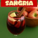 Pin Image: Title, a glass of sangria with apples and a cinnamon stick in it.