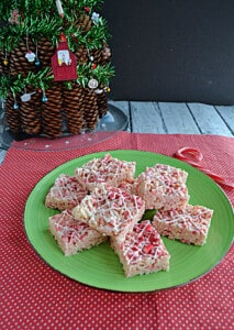 A plate of candy cane Rice Krispies Treats with a Christmas tree behind it.