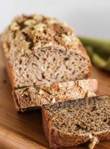 A loaf of vegan banana bread with two slices following down