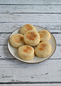 A plate of 6 golden brown English Muffins.