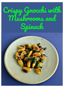 Pin Image: Text Overlay, a plate with a pile of crispy gnocchi, wilted spinach, and cooked mushrooms.