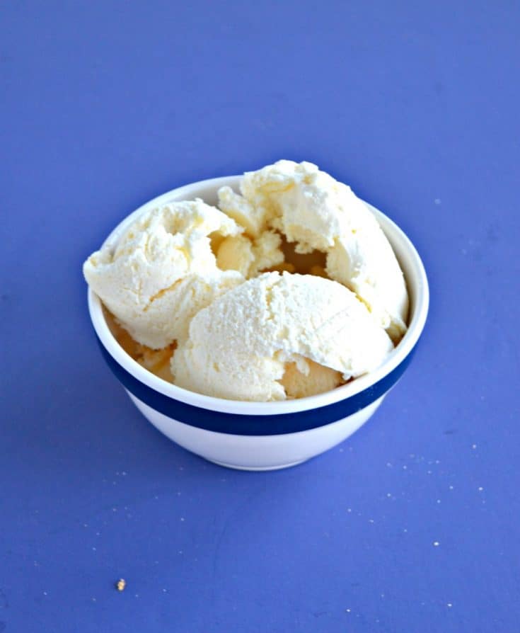 Three scoops of ice cream in a white bowl on a blue background.