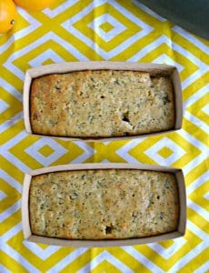 Two mini loaves of lemon poppyseed zucchini bread on a yellow and white placemat.