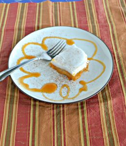 A plate with a squash of sweet potato haupia, a drizzle of caramel around the edges of the plate, a fork sitting behind the haupia, on an orange and green striped background.