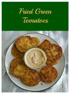 Pin Image: text overlay, a plate topped with golden brown fried green tomatoes and a bowl of remoulade in the middle.