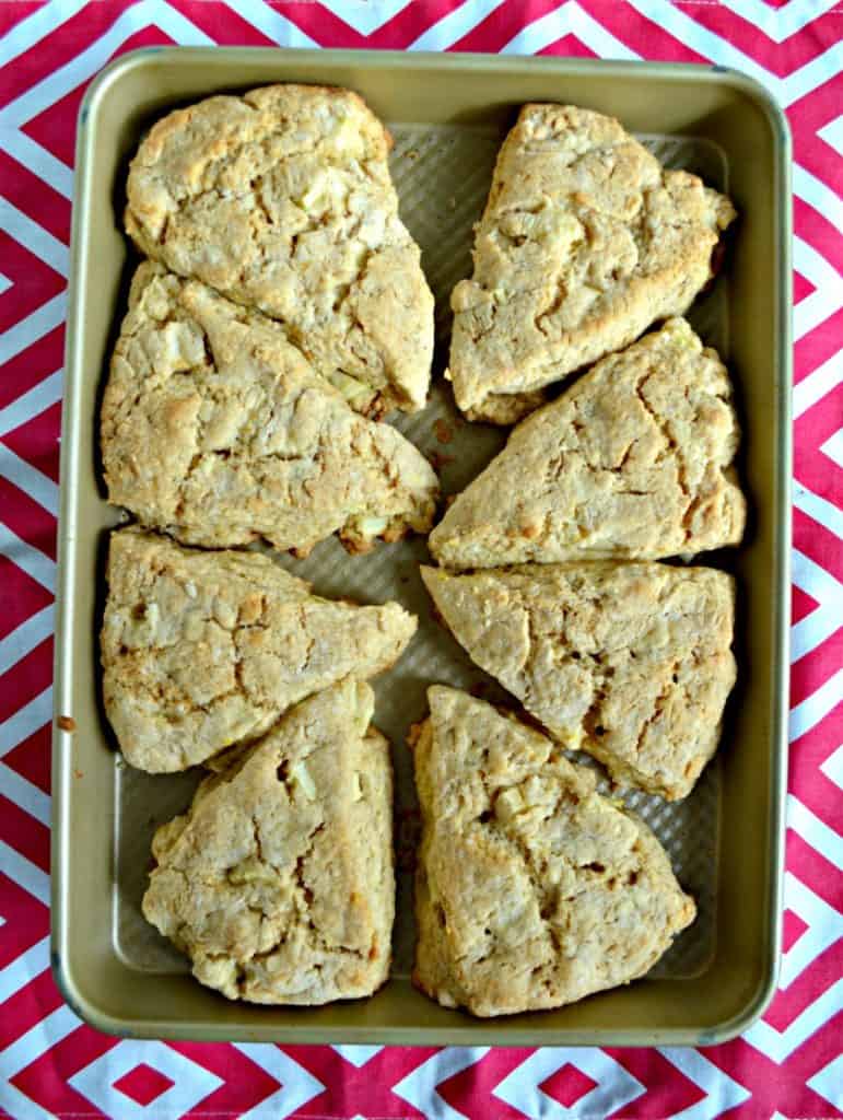A baking sheet with 8 triangles of scones arranged on it on a red and white background.