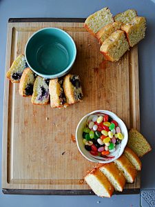 A cutting board topped with two bowls and slices of quick breads.