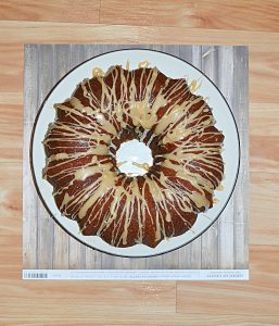 A plate topped with a gorgeous Bundt Cake with a golden drizzle all over top of it.