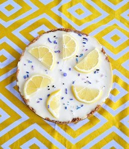 A cheesecake topped with lemon slices and purple sprinkles.