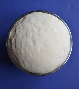 A bowl with dough burst out and over the top of it.