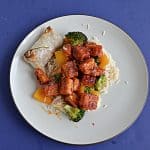 A plate topped with rice and sweet and spicy Firecracker tofu with broccoli.