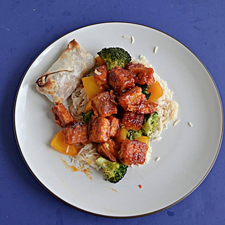 A plate topped with rice and sweet and spicy Firecracker tofu with broccoli.