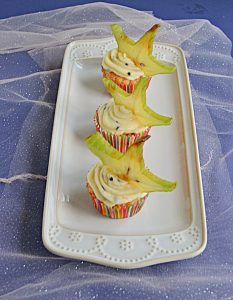 A white platter with 3 Tropical Cupcakes topped with a slice of star fruit.