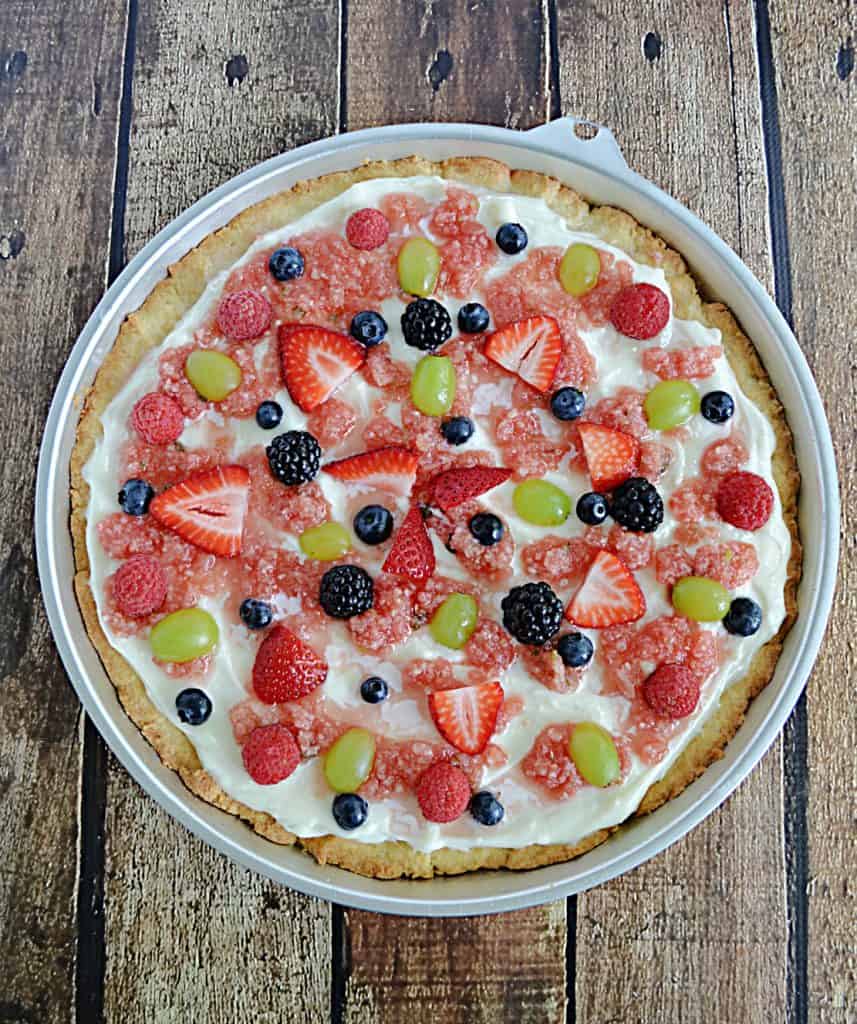 A fruit pizza topped with watermelon salsa and fresh fruit. 