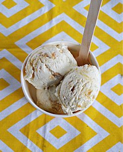 A top view of a bowl of Lemon Shortbread ice cream with a wooden spoon sticking out of it.
