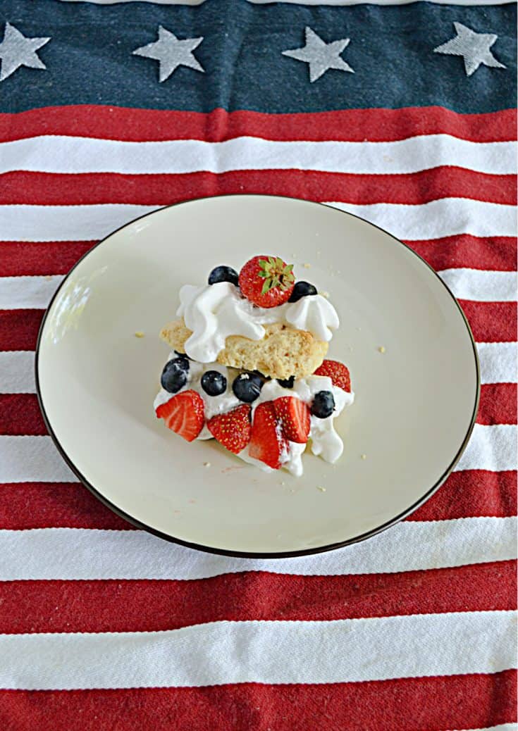 A front view of a shortcake made with biscuits, whipped cream, and berries.